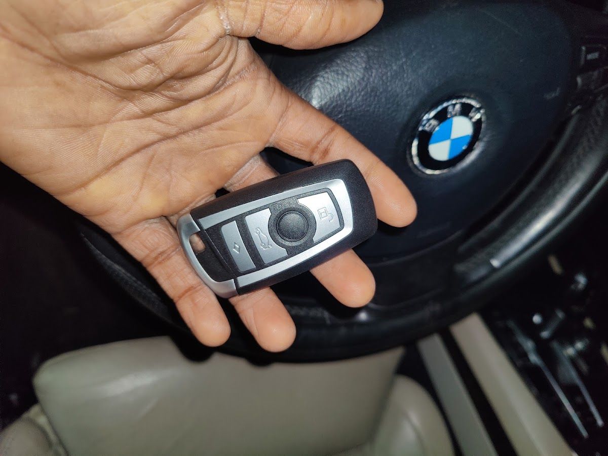 A replacement car key in hand at the steering wheel, programmed on-site